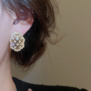 Gros plan de boucles d'oreilles ovales évidées en or avec zircons brillants