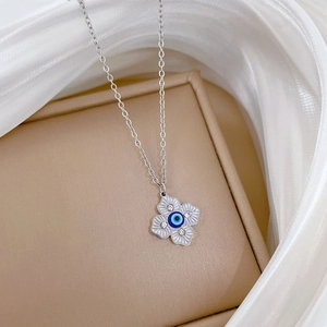 Detail of silver clover necklace with blue evil eye center and clear zircon accents