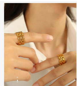 Close-up of dual wide golden chain design titanium steel rings worn by a model