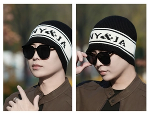 Détail du bonnet en maille noir et blanc avec motif rayé et lettres pixel NY & JA