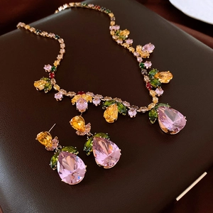 Detail shot of luxury jewelry set with pink pear-cut gemstones and floral accents
