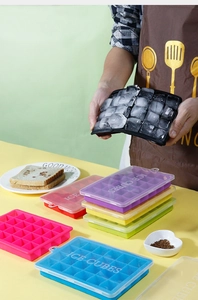Detailed view of colorful 24-cavity silicone ice cube trays with lids in a kitchen setting