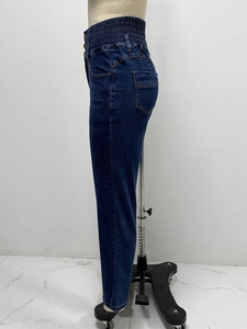 Close-up of high-waisted dark blue skinny jeans with multi-button closure and elastic fit