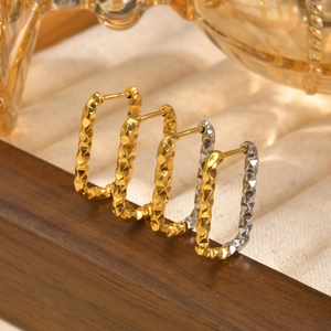 Macro view of gold stainless steel huggie earrings with textured diamond pattern
