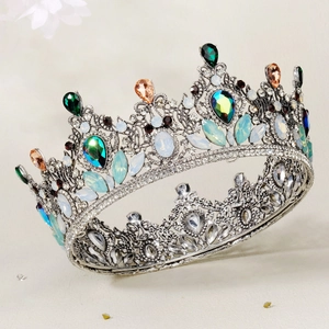 Macro detail of vintage silver Baroque crown with colorful crystals and hollow metal patterns