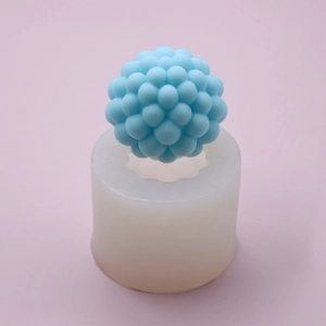 Detailed view of bubble sphere silicone mold and light blue textured DIY wax candle