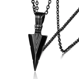 Detail view of a black geometric arrow pendant on a sleek metallic sweater chain