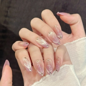 Pink purple gradient cat eye press-on nails with rhinestone accents on hands