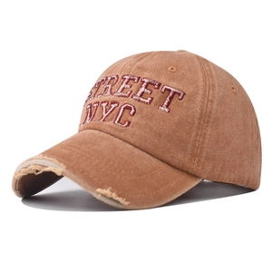 Close-up of vintage washed cotton baseball cap with red Street NYC embroidery and distressed brim