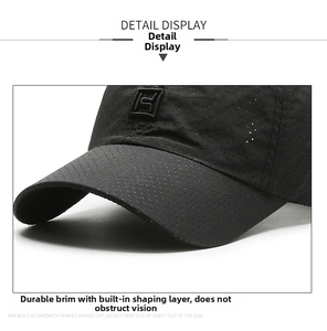 Detail of black baseball cap with breathable perforated fabric and square logo embroidery