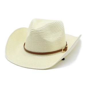 Détail d'un chapeau de cowboy en paille crème avec bande en cuir et boucle dorée
