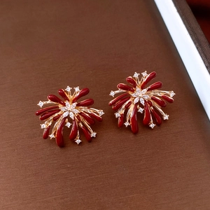 Macro shot of vintage firework earrings with red enamel and zircon stones in gold plating