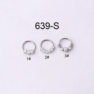 Macro detail of three 16G stainless steel septum clickers with cubic zirconia designs