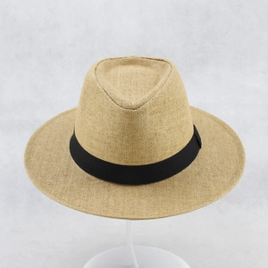Front detail of light coffee woven straw hat with classic black ribbon on support