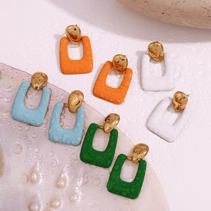 Close-up of geometric 18K gold plated earrings with colorful enamel and water drops