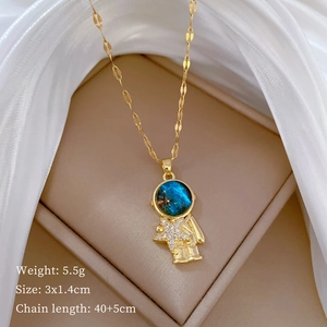 Close-up of gold astronaut necklace with blue starry face and diamond star pendant