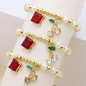 Set di 3 braccialetti dorati con perline, gemme rosse quadrate e ciondoli a ciliegia in strass