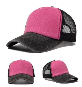 Detail view of washed mesh trucker hat showing rose red canvas and black breathable netting