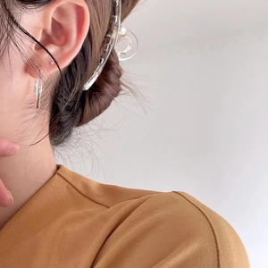 Close-up of minimalist 925 sterling silver Mobius earring on woman with transparent hair clip