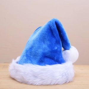 Close-up of blue plush Christmas hat with white faux fur trim on a wooden surface