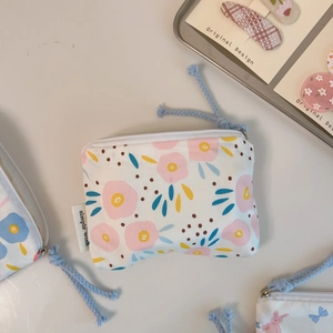 Detail of floral printed cotton mini pouches with rope zipper pull and woven label