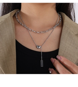 Detail of silver double-layered stainless steel necklace with rectangular pendant charm