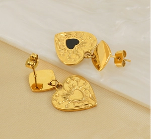 Vue macro de boucles d'oreilles cœur plaquées or 18 carats avec texture soleil