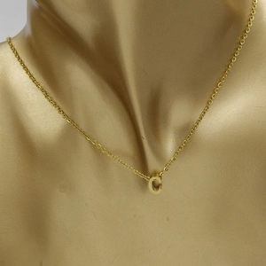 Detailed view of a gold-plated capital letter C pendant on a delicate chain necklace