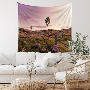 Detail of bohemian tapestry featuring a purple sunset landscape field over a white sofa