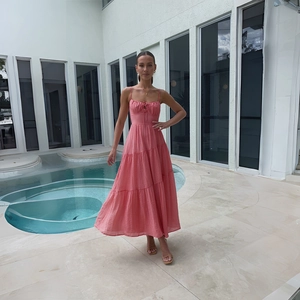 Details des rosa gestuften Maxikleides mit Spaghettiträgern und Strukturstoff am Pool