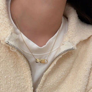 Close-up of a 925 sterling silver gold lock and key pendant necklace worn on a model