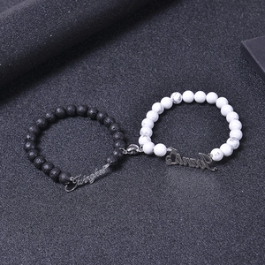 Detail of magnetic heart clasp connecting black lava and white marble beaded couple bracelets