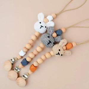 Three handmade crochet rabbit pacifier clips with natural beech wood beads in soft colors