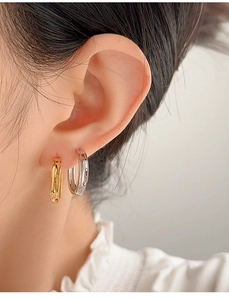 Close-up of minimalist S925 sterling silver hoop earrings in gold and silver finishes
