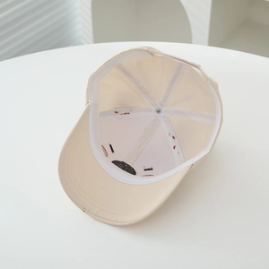 Internal view of cream kids cap showing six-panel cotton build and reinforced seams