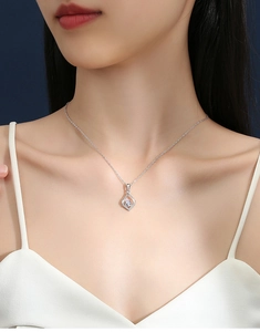 Detail of S925 silver necklace with diamond-shaped pendant worn on model's neck