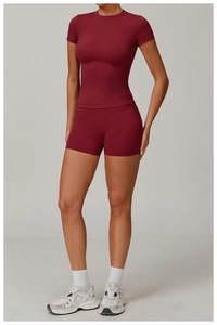 Close-up of slim fit dark red yoga set featuring high waist shorts and short sleeve top