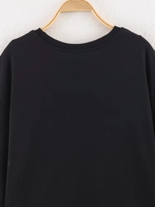 Detail of the crew neck and shoulder seam on this casual black short sleeve lace T-shirt