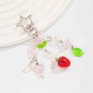 Dettaglio portachiavi a fragola con chiusura a stella, perle rosa e ali d'argento