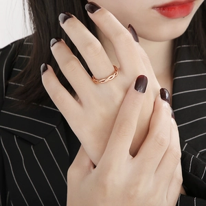 Detailed view of twisted rope ring in rose gold finish worn on a model's finger