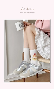 Détail de chaussettes en coton blanc avec broderie gâteau et bords ondulés festonnés