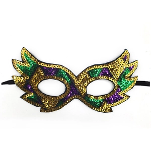 Gedetailleerd opname van een glinsterend pailletten oogmasker in goud, groen en paars.