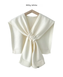 Detail of milky white knitted shawl showing fine texture, ribbed edges and R logo