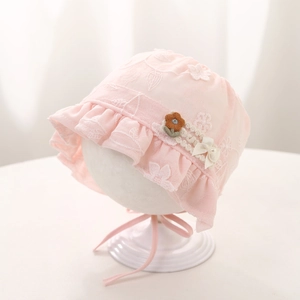 Close-up of baby lace sun hat with floral embroidery and pearl bow decoration