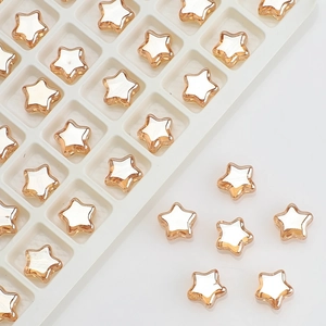 Close-up of 8mm gold-edged star beads with white pearl centers for jewelry making