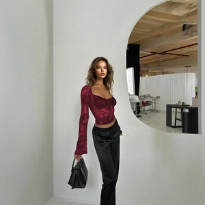 Détail du crop top en dentelle rouge foncé avec imprimé floral en velours et col en V