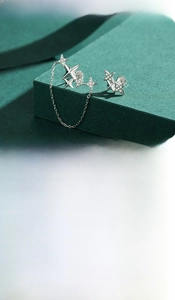Detail of 925 sterling silver star earrings with cubic zirconia and connecting chain