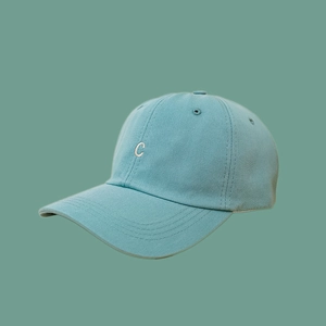 Close-up of a light teal baseball cap featuring 3D white embroidered letter C detail