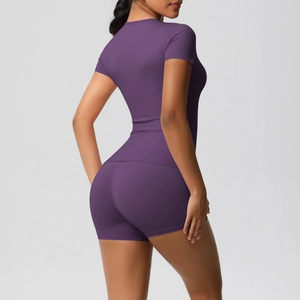 Rear view of tight purple yoga set showing slim fit short sleeve tee and high waist shorts