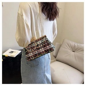Detail of colorful sequin chain bag with gold hardware worn on model in a cozy setting